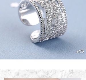 Macro detail of silver wide curved wave ring with shimmering pave-set cubic zirconia stones