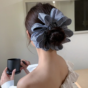 Detail of a large black and white checkered scrunchie with exaggerated ruffled edges