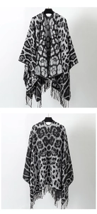 Flat lay of black and white leopard print knit shawl with fringe hem front and back view