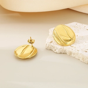 Macro detail of 18K gold stainless steel earrings with wavy texture on stone