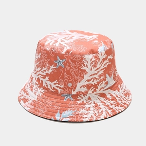 Detail of terracotta bucket hat featuring white coral and starfish patterns on fabric