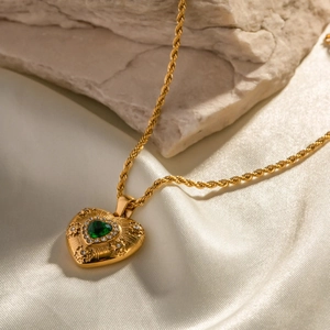 18k gold plated stainless steel necklace with green heart pendant on white silk fabric