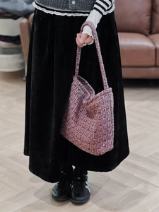Dettaglio ravvicinato della trama in tweed viola della borsa a spalla intrecciata