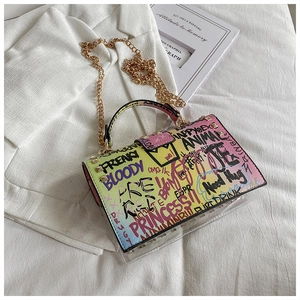 Close-up of graffiti jelly bag with gold chain strap and rivet details on bottom