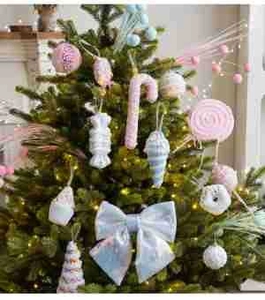 Pink and blue candy-themed Christmas ornaments on a tree with festive warm lighting
