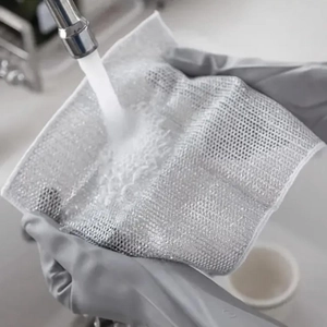 Close-up of wire dishcloth under running water showing mesh texture and easy rinsing