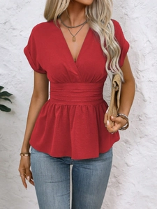 Detail of red V-neck top with pleated waist and ruffled hem, casual slim fit style