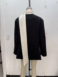 Détail d'un blazer noir avec col écharpe en satin crème contrastant vue de l'arrière