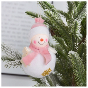 Detail of plush snowman ornament with pink knit hat and golden snowflake on pine branch