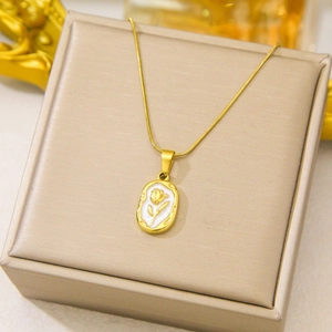 Elegant gold rose pendant necklace displayed on a champagne silk jewelry box cover