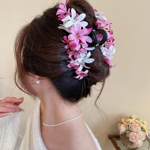 Détail d'une pince à cheveux avec fleurs en tissu rose et textures florales pour un style élégant