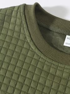 Detail of army green quilted texture and stitching on crewneck sweatshirt shoulder