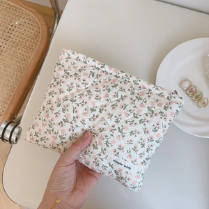 Macro detail of pink floral quilted cotton fabric and woven decorative label on the pouch