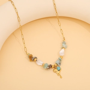 Detailed shot of beaded gemstone necklace with gold heart pendant on white stand