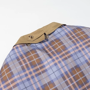 Detail of khaki collar and plaid lining with brown resin buttons on a woven jacket
