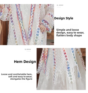 Dettaglio del cardigan boho in maglia bianca con ricami arcobaleno e lunghe frange