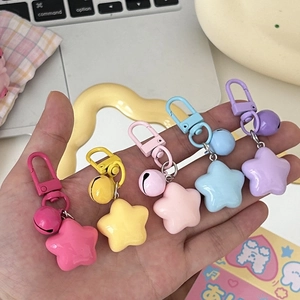 Macro detail of colorful macaron star-shaped bell keychains in five pastel colors