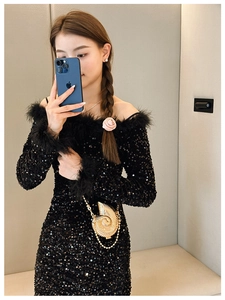 Detailed view of a mini conch-shaped gold metal handbag with textured spiral pattern