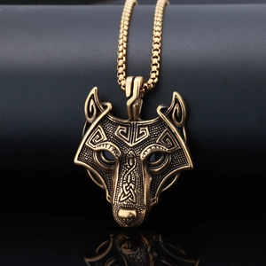 Detailed close-up of punk style wolf head pendant with antique bronze finish and box chain