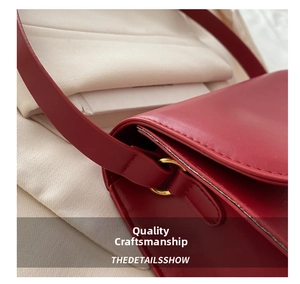 Detailed macro view of red leather texture and golden metal ring hardware on handbag