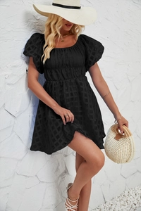 Détail d'une mini robe noire à manches bouffantes avec tissu à carreaux et encolure carrée