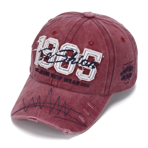 Detail of 1985 3D embroidery and distressed holes on vintage washed red cotton baseball cap