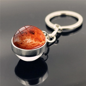Close-up of double-sided glass planet keychain with detailed Mars pattern and silver base