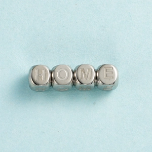 Détail de perles cubes argentées avec lettrage HOME pour création de bijoux DIY