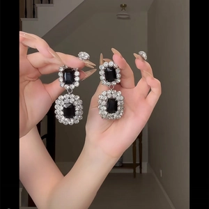 Detail of luxury long tassel flower earrings with black square cut gemstones and rhinestones