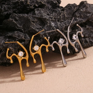 Detail of liquid lava style 18K gold earrings with zircons on volcanic rocks