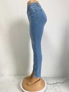 Detail von hellblauer Stretch-Jeans mit Destroyed-Effekten und Fransen am Saum