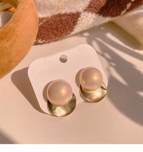 Close-up of elegant gold twisted circle earrings with champagne pearl and 925 silver needles