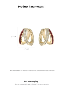 Detail view of 18K gold huggie earrings with red enamel and pavé zircon settings