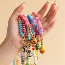 Detailed view of colorful beaded bracelets with vintage enamel egg charms on hand