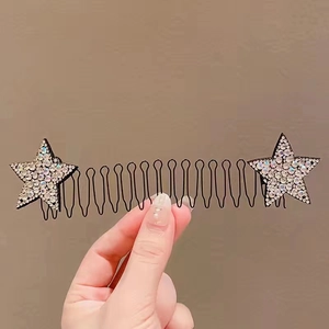 Close-up of wavy black hair comb with sparkling rhinestone stars for styling hair