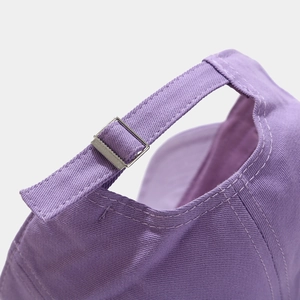 Detailed close-up of purple canvas baseball cap with adjustable metal buckle and stitching