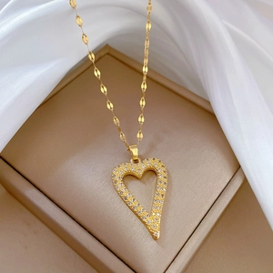 Gold heart pendant necklace with shimmering crystals on elegant silk background