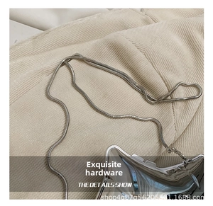 Detail shot of silver metallic star bag featuring polished finish and snake chain strap