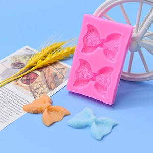 Pink bow silicone mold for chocolate and fondant cake decoration shown with colorful finished bows