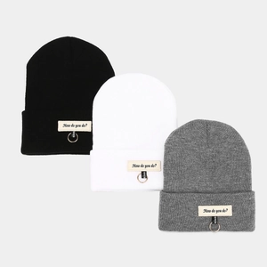 Trois bonnets en maille noir blanc et gris avec étiquettes lettrées et détails anneaux