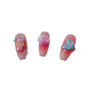 3D ocean-themed nail charms with pink seahorse, shell, and blue dolphin on pink nails