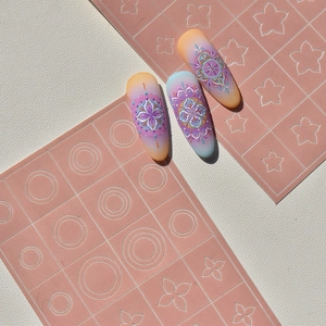 Gros plan de motifs mandala bohèmes en relief sur des ongles aux dégradés orange et bleu