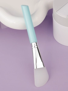Detail of soft silicone face mask brush with flat tip on soft purple background