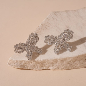 Macro detail of butterfly earrings with sparkling cubic zirconia on a white stone base