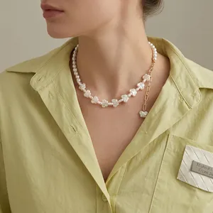 Irregular pearl heart necklace with gold flower pendant on model in soft lighting