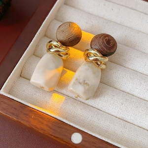 Detail of vintage geometric earrings with wood circles, gold metal rings, and resin stones