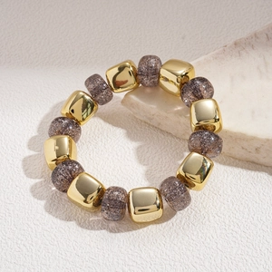 Detail of beaded bracelet with golden metal cubes and dark brown glitter acrylic beads