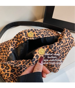 Detail view of leopard print canvas bucket bag with golden magnetic snap buttons