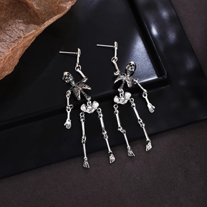 Detail view of vintage silver skeleton earrings on a black matte tray for Halloween