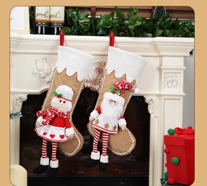 Detailed view of Santa and Mrs. Claus plush 3D stockings hanging on a white fireplace mantle